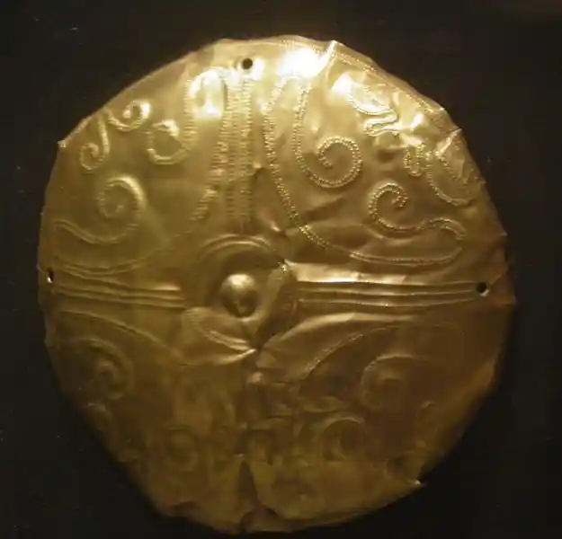 Cross with swirls engraved on a gold disc